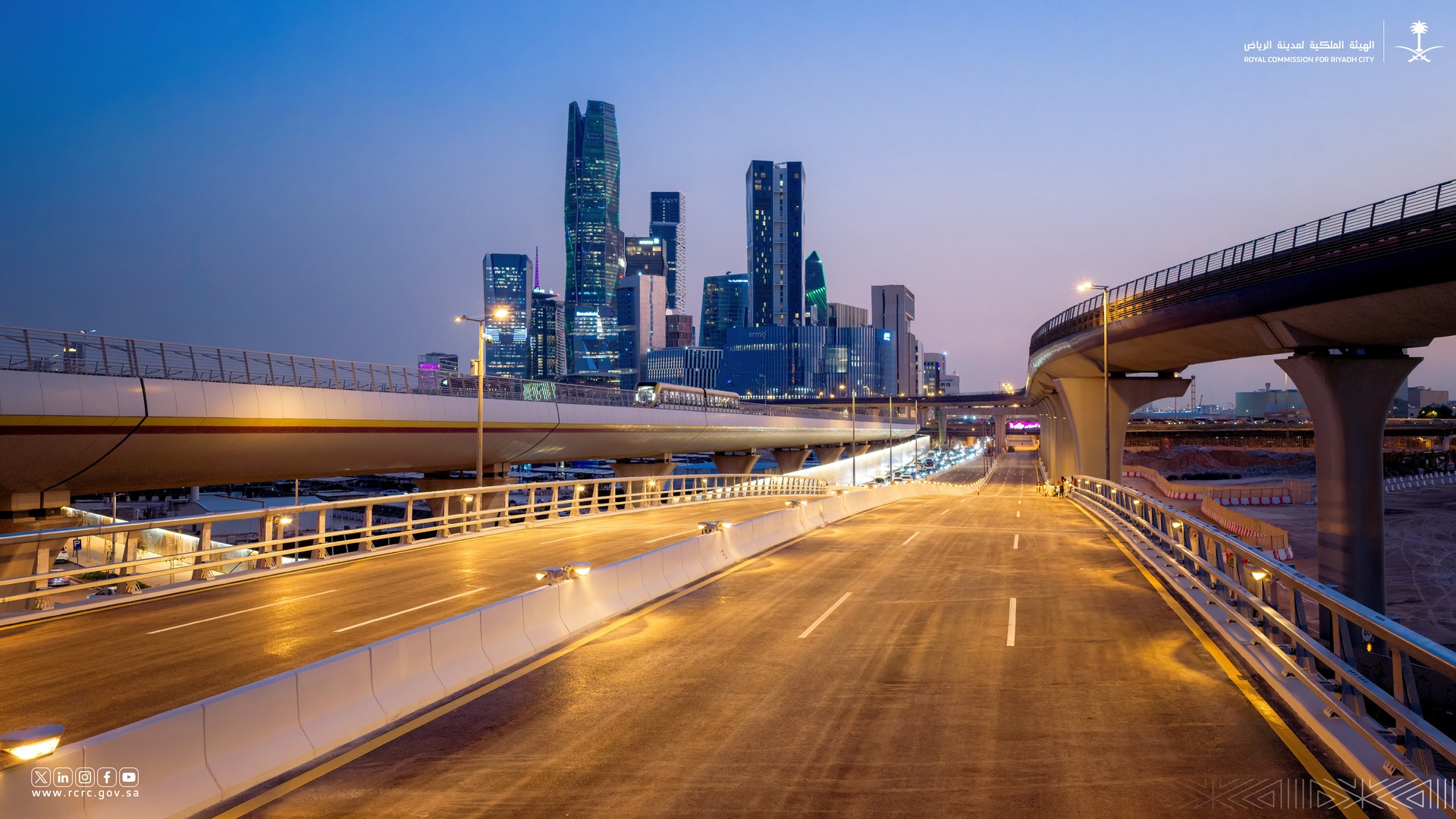 The new Al-Thumamah Road Bridge at dusk, beside the Riyadh Metro line and King Abdullah Financial District towers