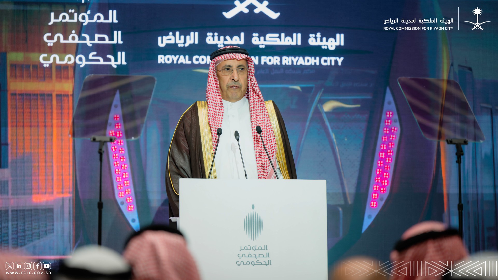 معالي المهندس إبراهيم السلطان على منصة المؤتمر الصحفي الحكومي أمام شعار الهيئة الملكية لمدينة الرياض